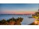 A peaceful waterfront view highlights the colorful sunset and nearby bridge at 420 Golden Gate Pt # 200A, Sarasota, FL 34236
