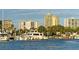 Picturesque Sarasota marina view featuring docked yachts against a backdrop of high-rise buildings and lush palm trees at 420 Golden Gate Pt # 200A, Sarasota, FL 34236