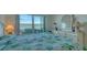 Bright bedroom with tranquil water views, a turtle themed quilt, and a white dresser with a lamp at 4420 Exeter Dr # L104, Longboat Key, FL 34228