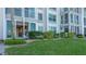Exterior of condominium featuring a balcony, a well-maintained lawn, and lush green hedges and landscaping at 4420 Exeter Dr # L104, Longboat Key, FL 34228