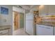 Bright kitchen with white cabinets, granite counters, and tile flooring, plus views to the hallway and laundry at 4420 Exeter Dr # L104, Longboat Key, FL 34228