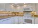 Clean kitchen featuring white cabinets, granite countertops, and modern appliances, creating an efficient space at 4420 Exeter Dr # L104, Longboat Key, FL 34228