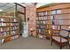Cozy library featuring floor-to-ceiling bookshelves filled with books and comfortable seating for reading at 4420 Exeter Dr # L104, Longboat Key, FL 34228