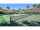 Well-maintained community tennis court, surrounded by palm trees, is ready for a match at 4420 Exeter Dr # L104, Longboat Key, FL 34228