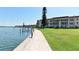 Picturesque waterfront with a dock and grassy area adjacent to the condominium buildings at 4420 Exeter Dr # L104, Longboat Key, FL 34228