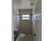 Compact bathroom featuring a shower with tiled walls, a window, and a granite countertop at 4444 Swift Rd # 14, Sarasota, FL 34231
