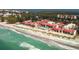 Beautiful aerial view of beachfront condos with red roofs and sparkling blue pool near the ocean at 4621 Gulf Of Mexico Dr # 2F, Longboat Key, FL 34228