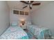 Charming bedroom with two twin beds, seashell-themed decor, and overhead fan at 4621 Gulf Of Mexico Dr # 2F, Longboat Key, FL 34228
