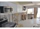 A kitchen being renovated shows stainless steel microwave and white cabinets, offering remodeling potential at 4621 Gulf Of Mexico Dr # 2F, Longboat Key, FL 34228