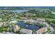Aerial view of lakefront community featuring buildings, tennis courts, lush landscaping, and parking at 4802 51St W St # 1711, Bradenton, FL 34210
