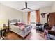 A well-lit bedroom with a fan, window with curtains, desk and hardwood floors at 4802 51St W St # 1711, Bradenton, FL 34210