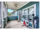 Enclosed porch with painted blue walls, ceiling fan, concrete floor, and exercise equipment at 4802 51St W St # 1711, Bradenton, FL 34210