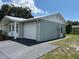 Side view of a well-maintained single-story home with a metal roof and attached garage at 4833 Dogwood St, New Port Richey, FL 34653