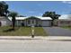 Inviting single-story home featuring a well-kept lawn, a charming palm tree, and a convenient paved driveway at 4833 Dogwood St, New Port Richey, FL 34653