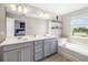 Bright bathroom featuring double sinks, a tub, and modern lighting fixtures at 5007 Sunnyside Ln, Bradenton, FL 34211