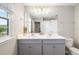 Double sink bathroom boasts an expansive mirror, ample lighting, and a gray vanity with abundant storage at 5007 Sunnyside Ln, Bradenton, FL 34211