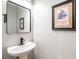 Stylish half-bath with a pedestal sink, modern fixtures, and decorative wall art at 5007 Sunnyside Ln, Bradenton, FL 34211