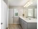 Dual sink bathroom boasts an expansive mirror, ample lighting, and a shower with linen curtain at 5007 Sunnyside Ln, Bradenton, FL 34211