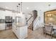 Bright kitchen features white cabinets, stainless steel appliances, and an island, next to stairway at 5007 Sunnyside Ln, Bradenton, FL 34211