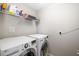 Bright laundry room features a washer and dryer, with overhead shelving for convenient storage solutions at 5007 Sunnyside Ln, Bradenton, FL 34211