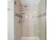 Walk-in shower features a chrome shower head, tiled surround, built-in shelving, and a decorative mosaic tile accent at 5007 Sunnyside Ln, Bradenton, FL 34211