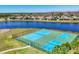 Aerial view of community tennis courts next to a pond and recreation area with a playground at 5033 Brickwood Rise Dr, Wimauma, FL 33598