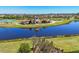 Scenic aerial view of the community clubhouse and playground area situated alongside a serene lake at 5033 Brickwood Rise Dr, Wimauma, FL 33598