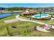 Aerial view showcases a community dog park, pool, and clubhouse near a tranquil lake at 5033 Brickwood Rise Dr, Wimauma, FL 33598