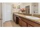 Bathroom featuring a granite countertop, double sinks, wood cabinetry, and walk-in shower at 5033 Brickwood Rise Dr, Wimauma, FL 33598