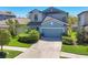 Charming two-story home featuring lush landscaping, a well-manicured lawn, and an attached two-car garage at 5033 Brickwood Rise Dr, Wimauma, FL 33598