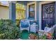 Inviting front porch with cozy seating, decorative pillows, vibrant plants, and a charming wreath on the door at 5033 Brickwood Rise Dr, Wimauma, FL 33598