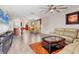 Open-concept living space connecting a living room, dining area with yellow chairs, and a kitchen with bar seating at 5033 Brickwood Rise Dr, Wimauma, FL 33598