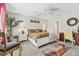 Well-lit main bedroom featuring a ceiling fan, a decorative rug, and a charming accent chair at 5033 Brickwood Rise Dr, Wimauma, FL 33598