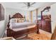 The main bedroom features an antique carved wood bed, dresser, and ceiling fan at 5033 Brickwood Rise Dr, Wimauma, FL 33598