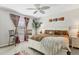 Spacious main bedroom featuring a comfortable white bed, an accent chair, and light colored walls at 5033 Brickwood Rise Dr, Wimauma, FL 33598