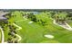 Beautiful aerial view of a meticulously maintained golf course with sand traps and palm tree accents at 52 Grande Fairway, Englewood, FL 34223