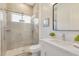 Modern bathroom featuring a tiled walk-in shower with glass door and a sleek vanity with a large mirror at 52 Grande Fairway, Englewood, FL 34223