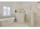 Luxurious bathroom with a marble shower stall and freestanding tub illuminated by natural light at 52 Grande Fairway, Englewood, FL 34223