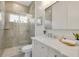 Modern bathroom featuring a tiled walk-in shower with glass door and a sleek vanity with a large mirror at 52 Grande Fairway, Englewood, FL 34223