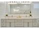 Bright bathroom featuring a double vanity with marble counters, shiplap walls, and a large mirror at 52 Grande Fairway, Englewood, FL 34223