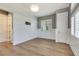 Bedroom features wood-look flooring, paneled walls, a large window with shutters and two doors at 52 Grande Fairway, Englewood, FL 34223
