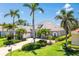 Beautiful home exterior with lush landscaping, palm trees, and a brick driveway at 52 Grande Fairway, Englewood, FL 34223