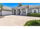 Attractive home exterior with a brick driveway, arched entryway, and manicured bushes at 52 Grande Fairway, Englewood, FL 34223