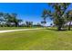 Picturesque view of the golf course with meticulously maintained green, trees, and clear blue skies at 52 Grande Fairway, Englewood, FL 34223