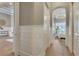 Hallway with hardwood floors, white wainscoting, and an archway leading to the bedroom at 52 Grande Fairway, Englewood, FL 34223