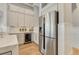 Modern kitchen featuring a stainless steel refrigerator, wine cooler, and custom cabinetry at 52 Grande Fairway, Englewood, FL 34223