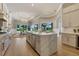 Spacious kitchen with stainless steel appliances, marble countertops, a center island, and hardwood floors at 52 Grande Fairway, Englewood, FL 34223