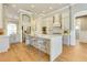 Gourmet kitchen with stainless steel appliances, quartz countertops, an island with seating, and hardwood flooring at 52 Grande Fairway, Englewood, FL 34223