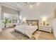 Bright main bedroom with white wainscoting walls, hardwood floors, and plantation shutters at 52 Grande Fairway, Englewood, FL 34223