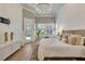 Bright main bedroom with a view of the pool, white wainscoting, hardwood floors, and plantation shutters at 52 Grande Fairway, Englewood, FL 34223